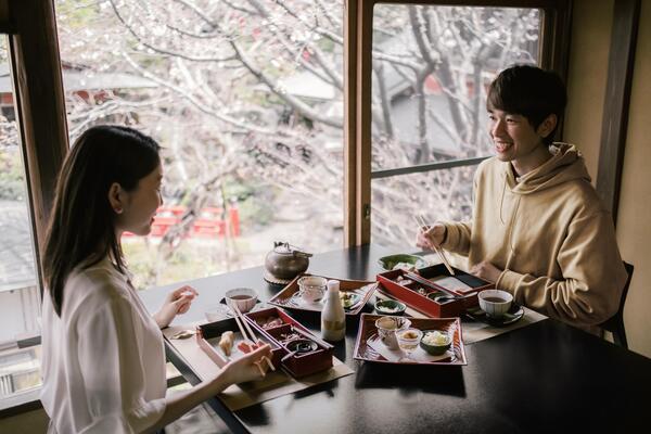 um casal sentado a mesa comendo sushi juntos no japao